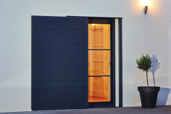 Des volets coulissants bleu sur une maison blanche.