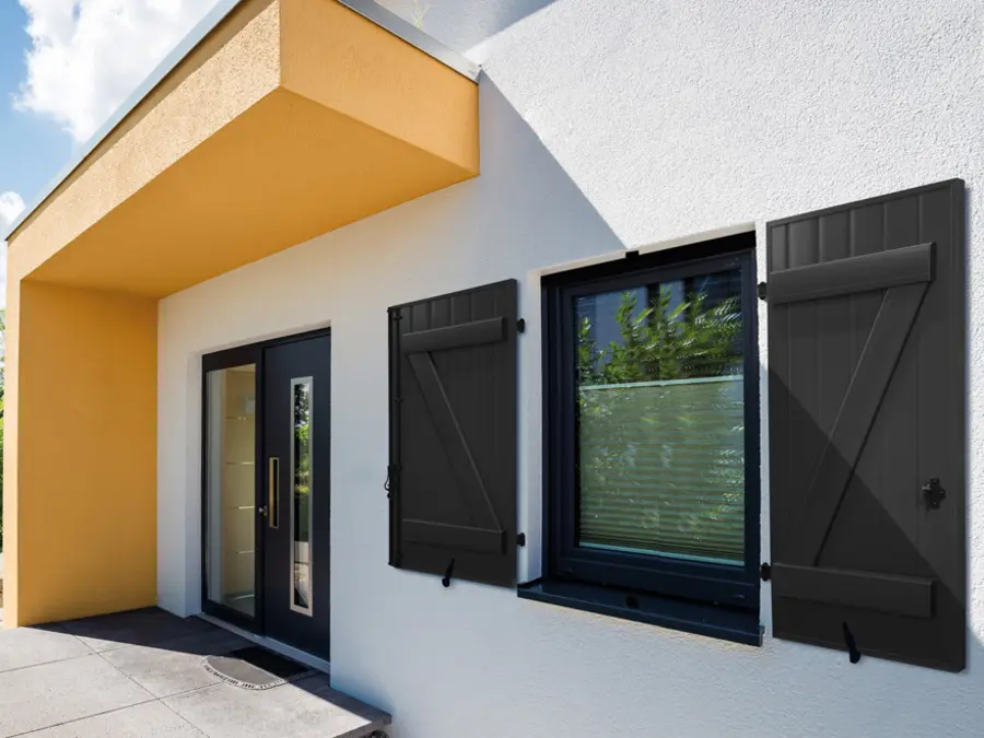 Des volets battants noir sur une maison blanche.